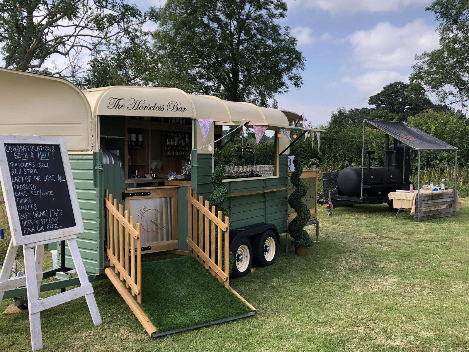 Horsebox bar at a summer wedding with chalkboard drinks menu